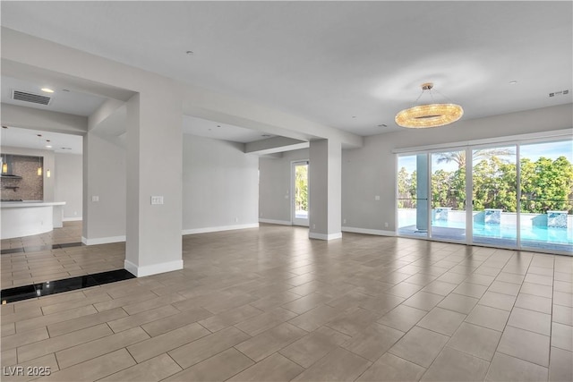 unfurnished living room featuring visible vents and baseboards