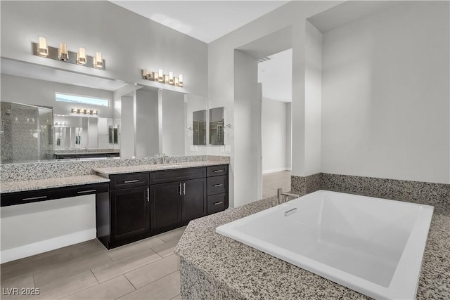 bathroom with a soaking tub, a shower stall, and vanity