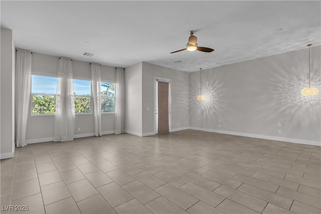 unfurnished room with ceiling fan, visible vents, and baseboards