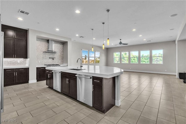 kitchen with a sink, light countertops, stainless steel dishwasher, wall chimney exhaust hood, and tasteful backsplash