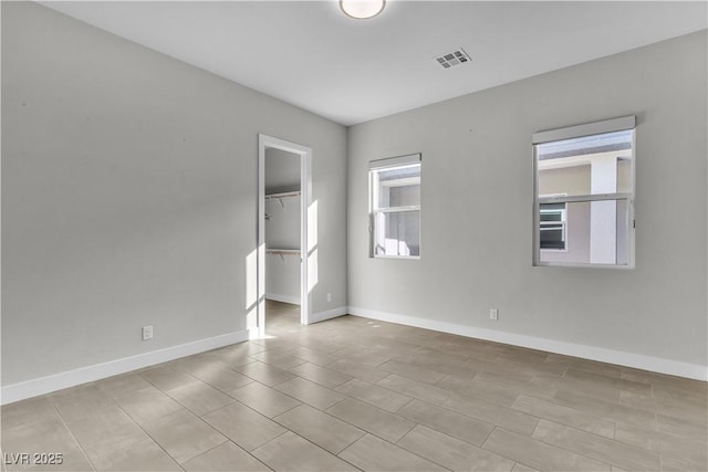 unfurnished room with visible vents and baseboards