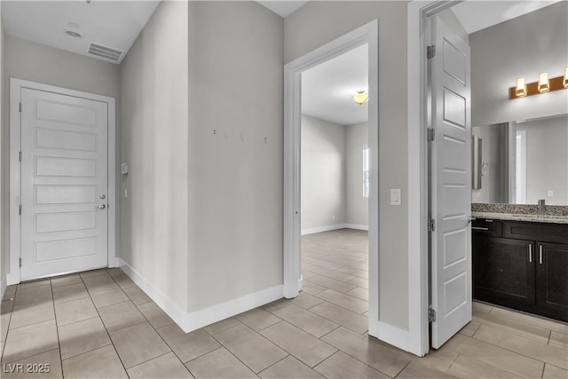 interior space with a sink, visible vents, and baseboards