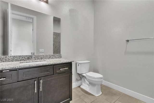 bathroom with toilet, tile patterned flooring, baseboards, and vanity