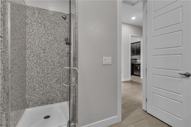 bathroom with tile patterned flooring, a shower stall, and baseboards