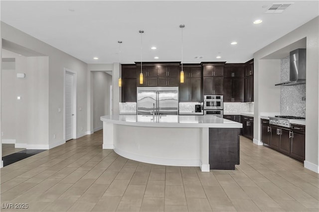 kitchen featuring tasteful backsplash, light countertops, visible vents, appliances with stainless steel finishes, and wall chimney range hood