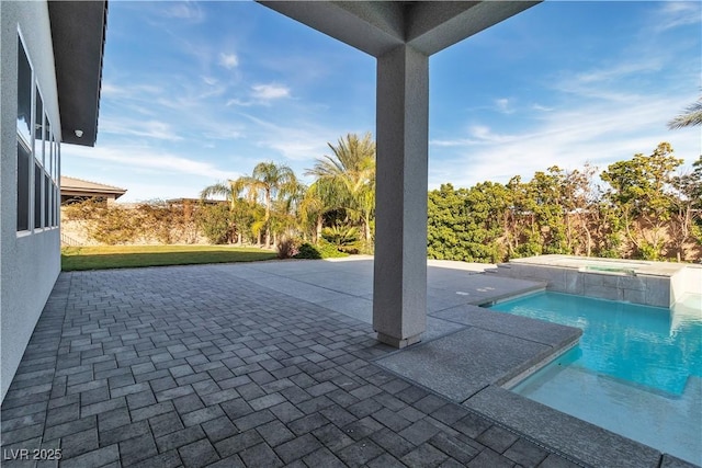 pool with a patio and an in ground hot tub