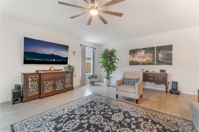 living room featuring ceiling fan, wood finished floors, and baseboards