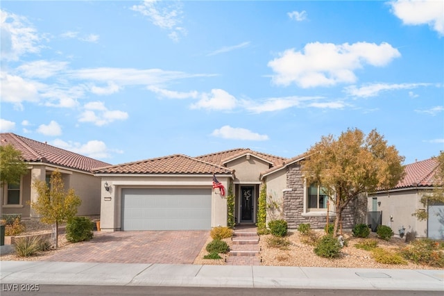 view of front facade with decorative driveway, a tile roof, stucco siding, an attached garage, and stone siding