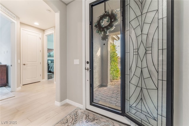 foyer entrance featuring light wood-style floors and baseboards