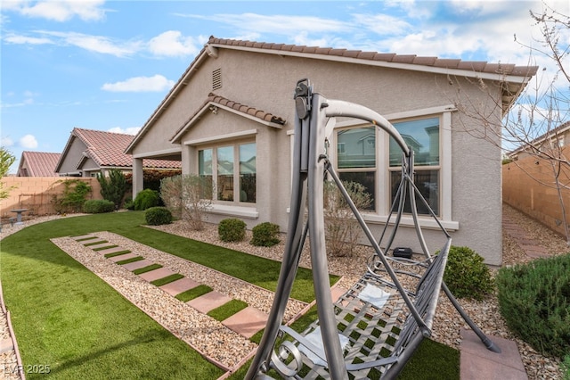 exterior space with a fenced backyard, a lawn, and stucco siding