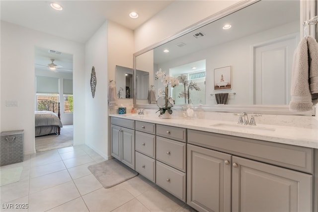 ensuite bathroom featuring double vanity, tile patterned flooring, a sink, and visible vents