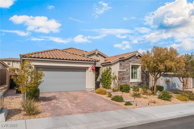 view of front of property featuring an attached garage, fence, stone siding, decorative driveway, and stucco siding