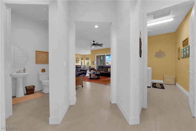 hall with recessed lighting and baseboards