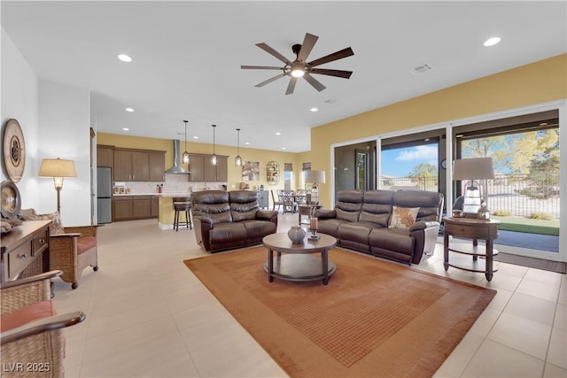 living area with light tile patterned floors, ceiling fan, visible vents, and recessed lighting