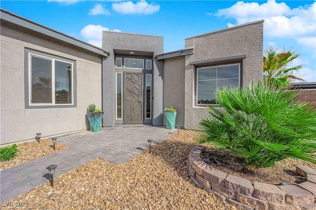 entrance to property featuring stucco siding