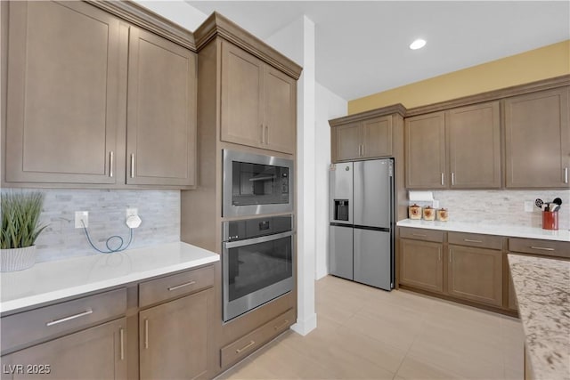 kitchen featuring light countertops, appliances with stainless steel finishes, recessed lighting, and tasteful backsplash