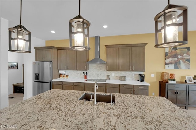 kitchen featuring stainless steel fridge, decorative backsplash, black electric stovetop, wall chimney range hood, and a sink