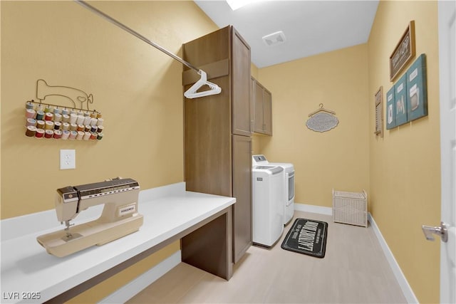 clothes washing area with cabinet space, visible vents, baseboards, and separate washer and dryer