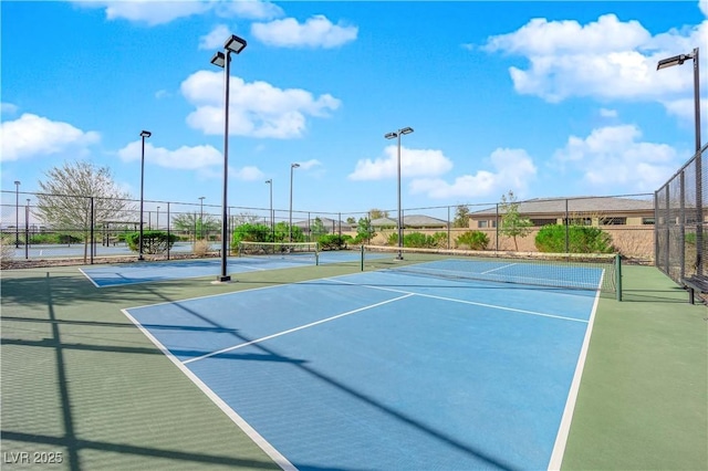 view of tennis court featuring fence