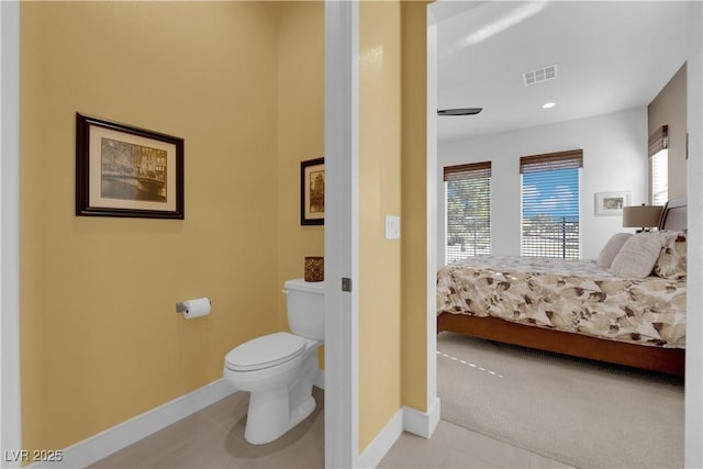 ensuite bathroom featuring toilet, visible vents, baseboards, and connected bathroom