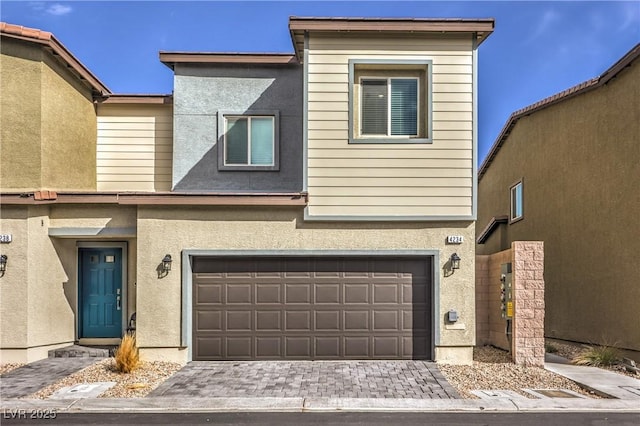 multi unit property featuring decorative driveway, an attached garage, and stucco siding