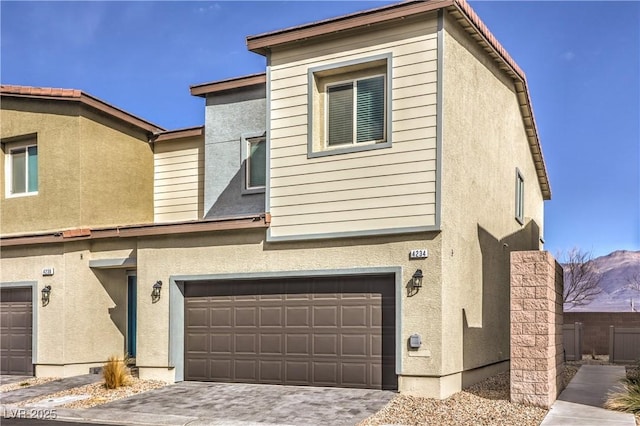 multi unit property featuring a garage, decorative driveway, and stucco siding