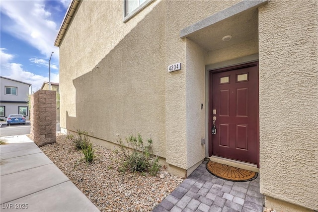 view of exterior entry featuring stucco siding