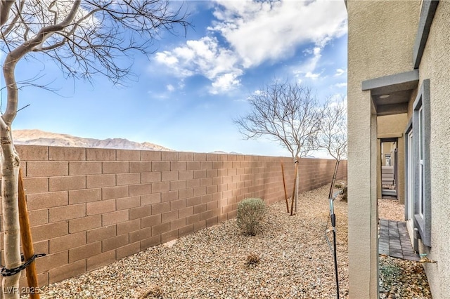 view of yard with a fenced backyard and a mountain view