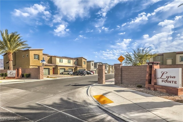 view of road featuring traffic signs, a residential view, curbs, and sidewalks