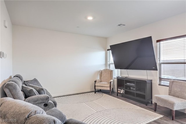 living area with recessed lighting, visible vents, baseboards, and wood finished floors