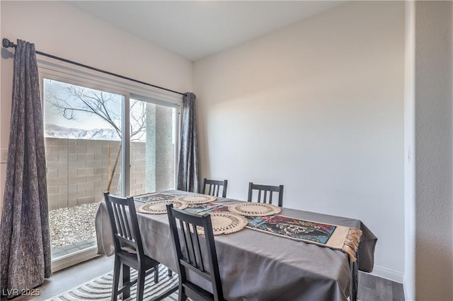 dining space featuring wood finished floors and baseboards