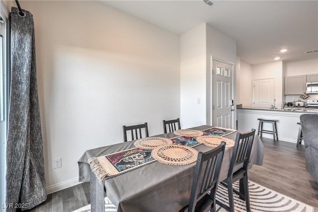 dining room featuring dark wood-style floors, baseboards, and recessed lighting