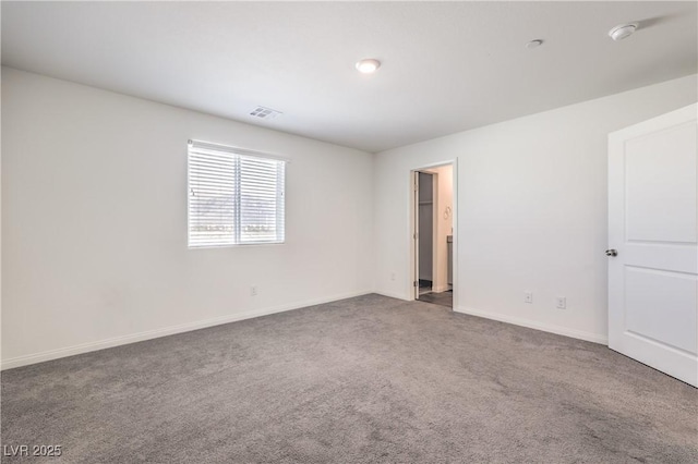 spare room featuring carpet floors, baseboards, and visible vents