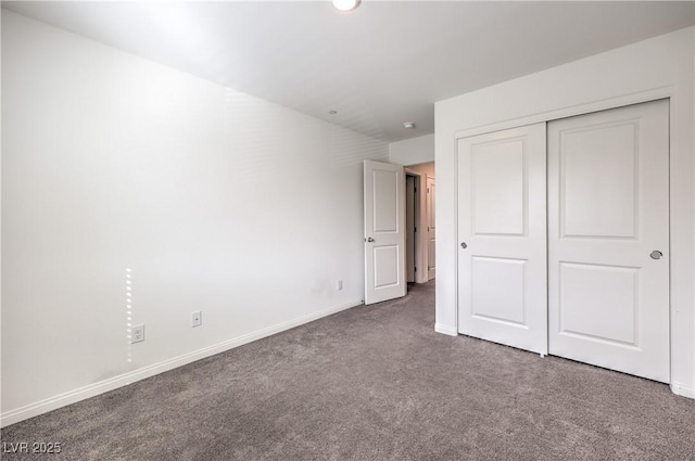 unfurnished bedroom featuring carpet, baseboards, and a closet