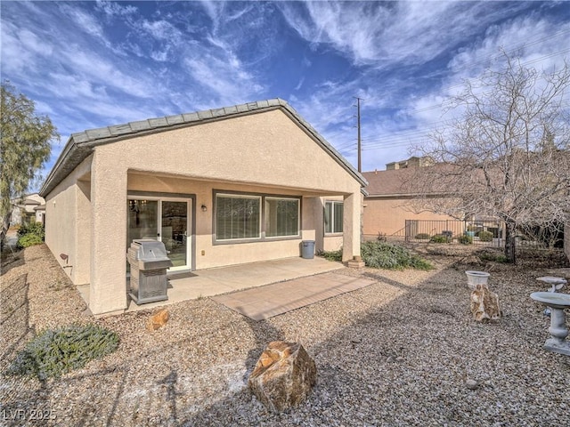 back of house with a patio, fence, and stucco siding