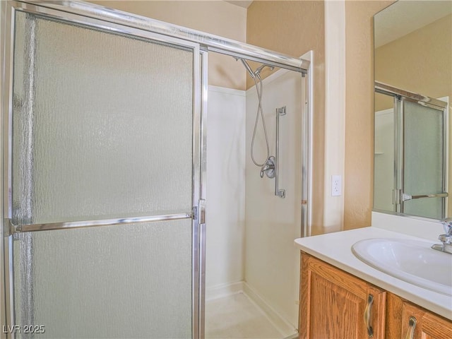 bathroom with a shower stall and vanity