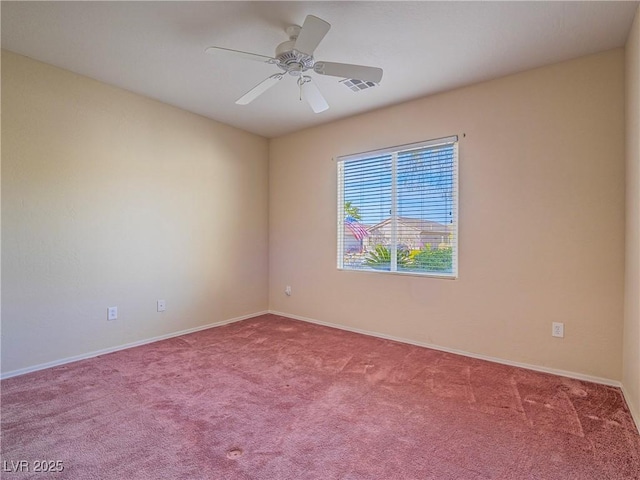 carpeted spare room featuring ceiling fan, visible vents, and baseboards