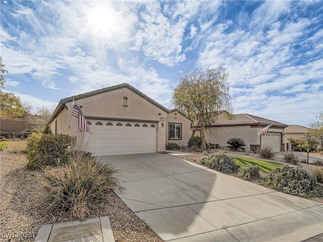 view of front facade featuring a garage, concrete driveway, and stucco siding