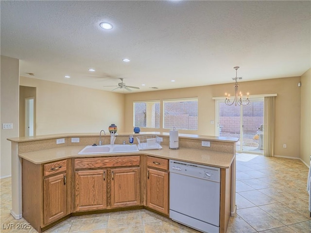 kitchen with dishwasher, light countertops, a sink, and a healthy amount of sunlight