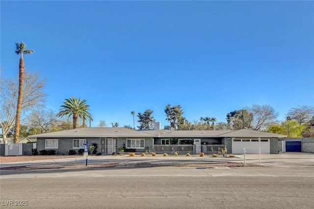 ranch-style house with an attached garage, concrete driveway, and fence