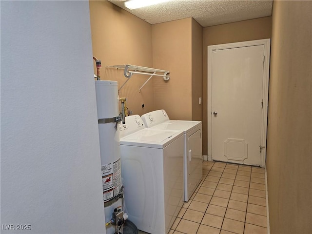 laundry room featuring laundry area, washing machine and clothes dryer, a textured ceiling, gas water heater, and light tile patterned flooring