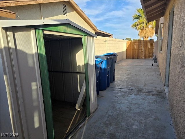 view of side of property featuring a shed, an outdoor structure, and fence