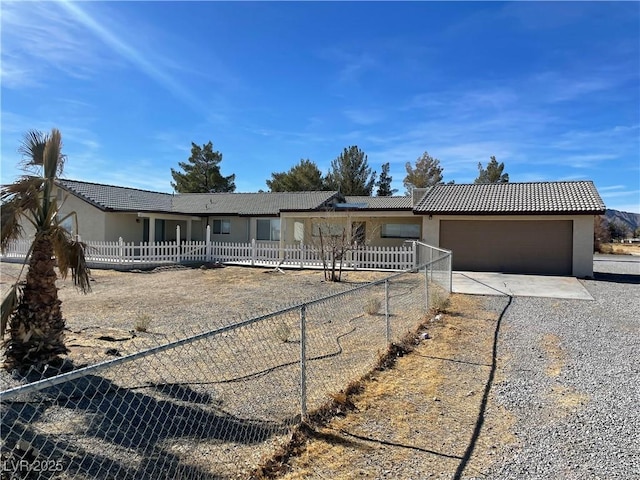 ranch-style house with a garage, a tile roof, fence, concrete driveway, and stucco siding