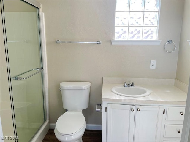 bathroom with toilet, an enclosed shower, and vanity