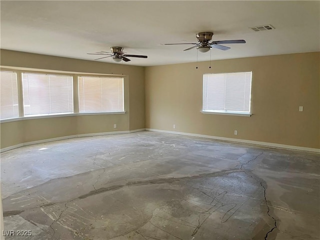 unfurnished room with concrete floors, visible vents, plenty of natural light, and baseboards