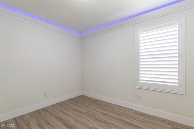 spare room featuring baseboards and wood finished floors