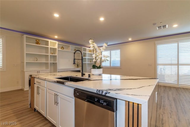 kitchen featuring visible vents, dishwasher, a kitchen island with sink, white cabinetry, and a sink