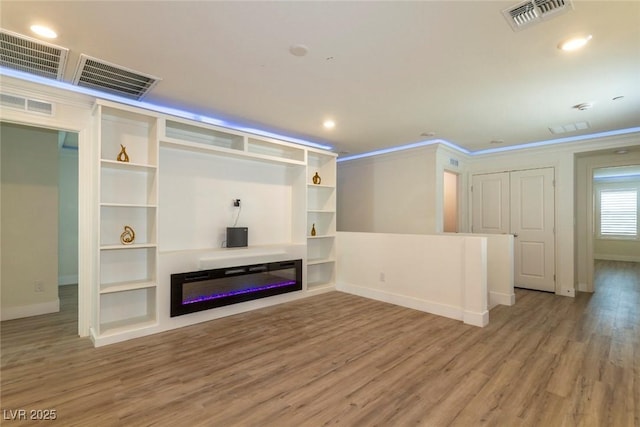 unfurnished living room with wood finished floors and visible vents