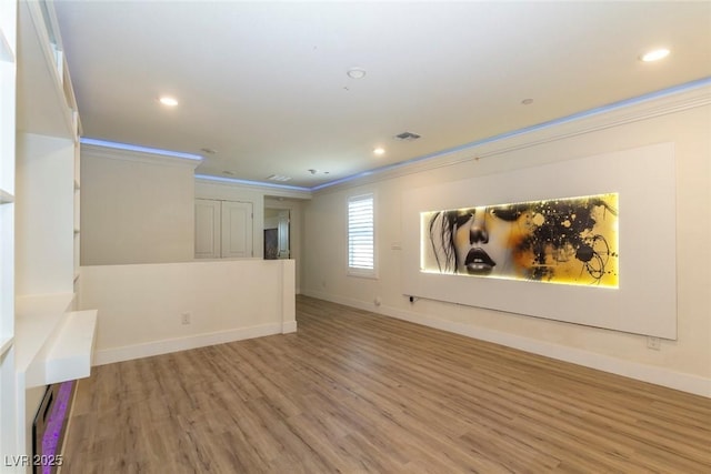 spare room with light wood finished floors, ornamental molding, recessed lighting, and baseboards