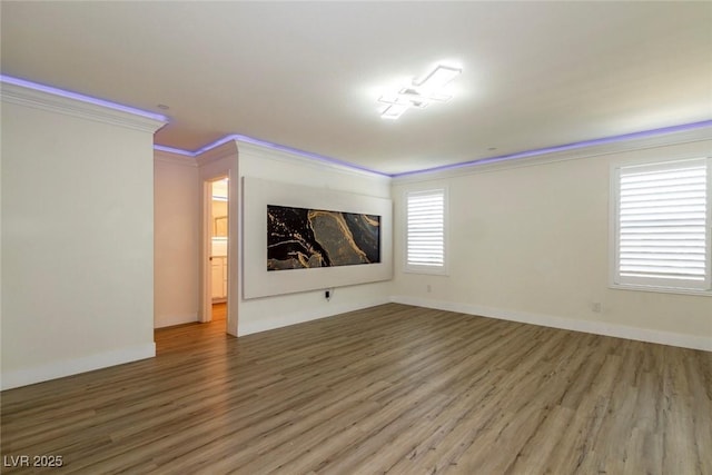 interior space featuring baseboards, crown molding, and wood finished floors